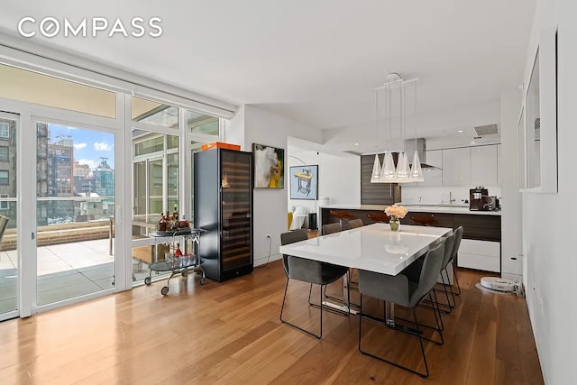 dining area featuring a city view, wood finished floors, and expansive windows