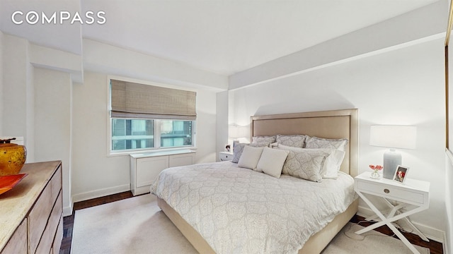 bedroom with baseboards and wood finished floors