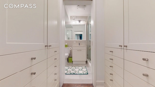 full bathroom featuring toilet, a shower stall, vanity, and baseboards