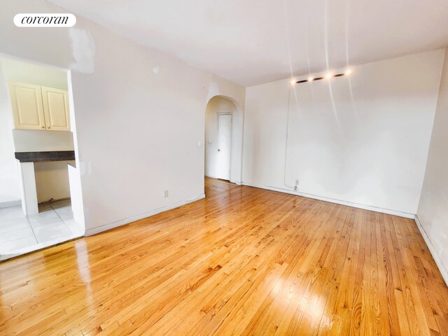 762 Brady Ave Unit 621, New York City, NY 10462 - empty room featuring arched walkways, light wood-type flooring, and baseboards