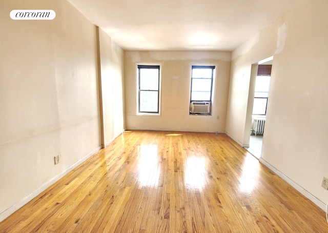 762 Brady Ave Unit 621, New York City, NY 10462 - empty room with radiator, light wood-style floors, baseboards, and cooling unit