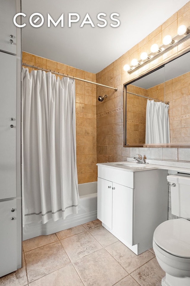 full bath with vanity, tile walls, toilet, and shower / bathtub combination with curtain