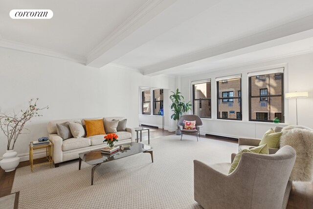 living area featuring visible vents, ornamental molding, wood finished floors, beamed ceiling, and baseboards