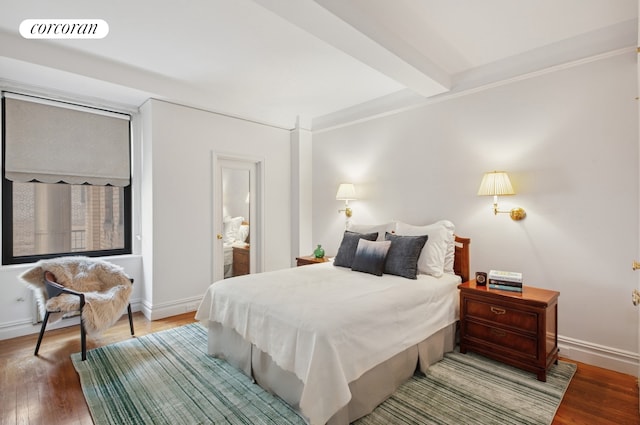 bedroom with visible vents, ornamental molding, baseboards, and wood finished floors