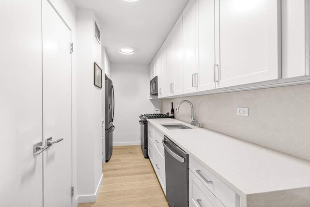 444 E 86th St Unit 21J, New York City, NY 10028 - kitchen with light wood-style flooring, freestanding refrigerator, gas range, dishwasher, and a sink