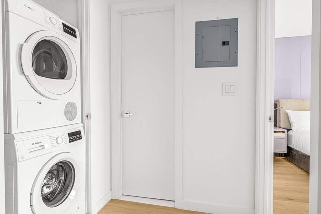 444 E 86th St Unit 21J, New York City, NY 10028 - washroom featuring light wood-type flooring, laundry area, stacked washer and clothes dryer, and electric panel