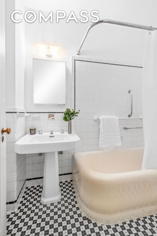 bathroom with tile patterned floors, tile walls, and shower / tub combo with curtain