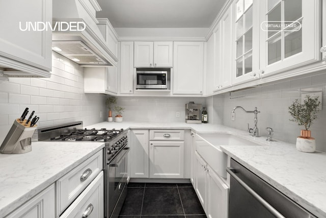 130 E 94th St Unit 2-E, New York City, NY 10128 - kitchen featuring stainless steel appliances, white cabinetry, dark tile patterned floors, and decorative backsplash