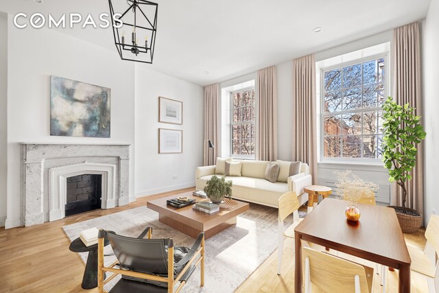119 Henry St Unit 3, New York City, NY 11201 - living area featuring wood finished floors, baseboards, a chandelier, and a fireplace