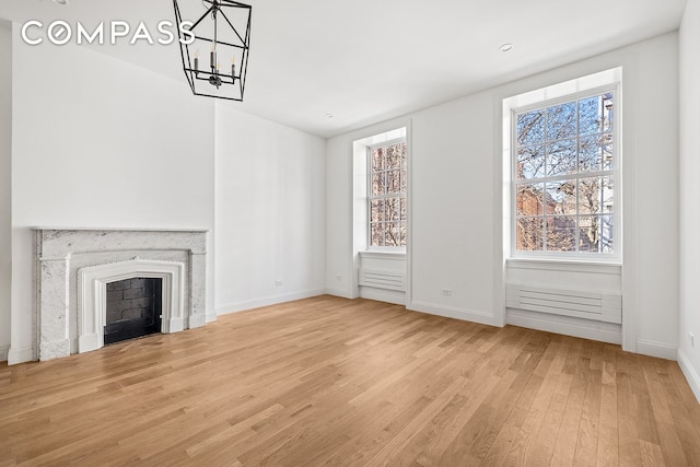 119 Henry St Unit 3, New York City, NY 11201 - unfurnished living room with wood finished floors, healthy amount of natural light, a chandelier, and baseboards