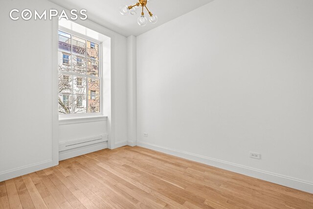 119 Henry St Unit 3, New York City, NY 11201 - empty room featuring a chandelier, light wood-style flooring, baseboards, and healthy amount of natural light
