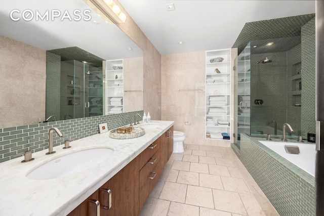 bathroom featuring double vanity, tile walls, a stall shower, and a sink