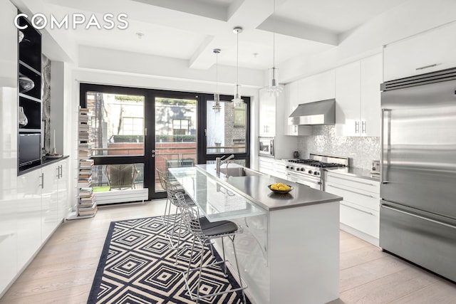kitchen featuring built in appliances, white cabinets, modern cabinets, and coffered ceiling