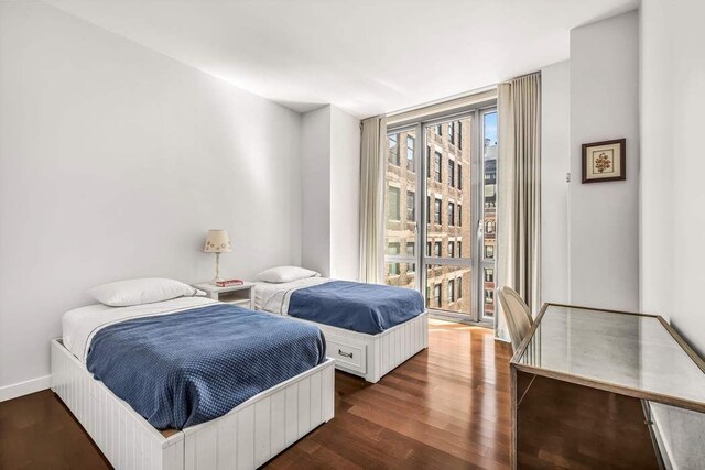 4 W 21st St Unit 10D, New York City, NY 10010 - bedroom featuring access to outside, baseboards, and dark wood-style floors