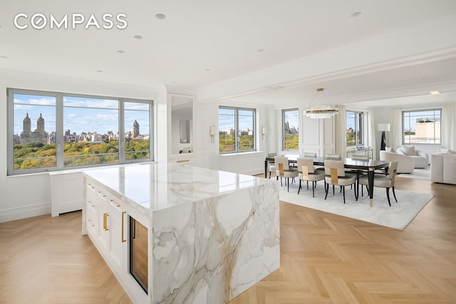 kitchen with white cabinets, open floor plan, plenty of natural light, and baseboards