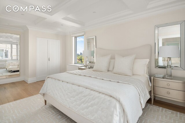 bedroom featuring light wood-style flooring, coffered ceiling, baseboards, beam ceiling, and ornamental molding