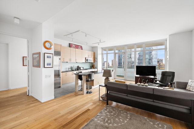 325 5th Ave Unit 34D, New York City, NY 10016 - living area with light wood-style flooring, rail lighting, and baseboards