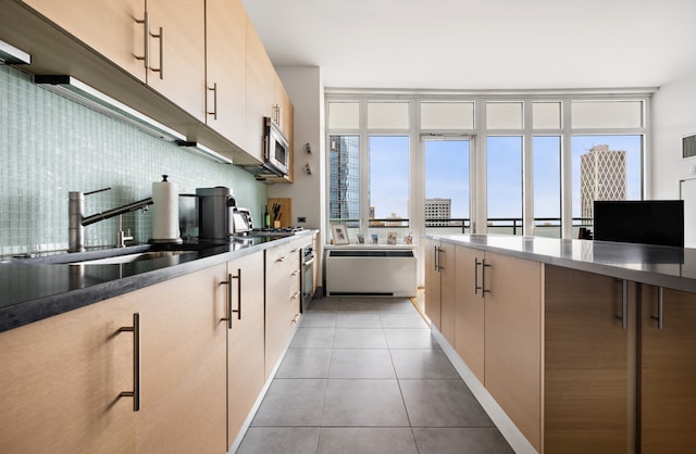 325 5th Ave Unit 34D, New York City, NY 10016 - kitchen featuring stainless steel microwave, backsplash, and light tile patterned flooring