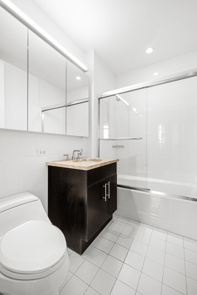 325 5th Ave Unit 34D, New York City, NY 10016 - bathroom featuring toilet, vanity, combined bath / shower with glass door, tile patterned floors, and recessed lighting