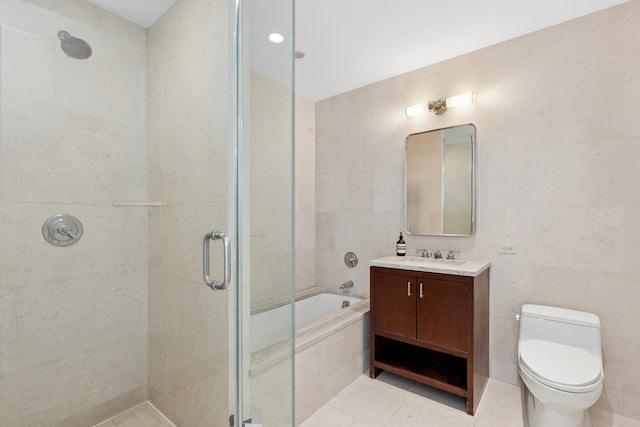 bathroom with tiled shower, a bathtub, vanity, toilet, and tile patterned flooring
