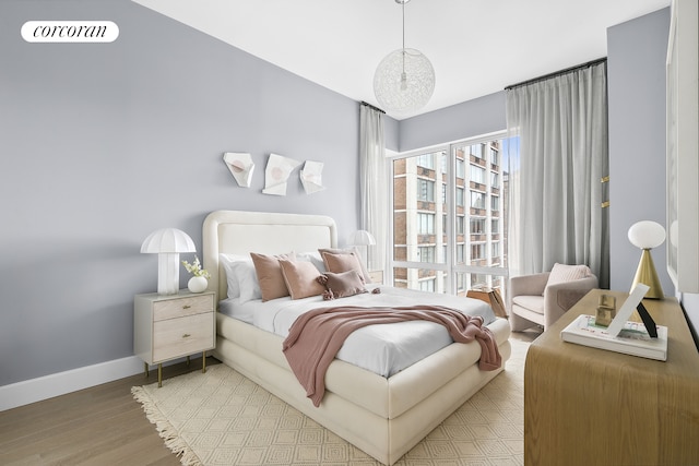 bedroom featuring baseboards and wood finished floors