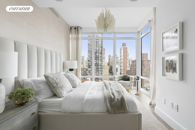 bedroom featuring a view of city, baseboards, visible vents, and wood finished floors