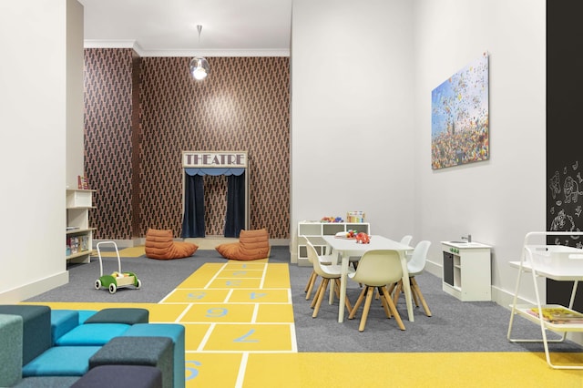 recreation room featuring ornamental molding, shuffleboard, carpet flooring, and baseboards