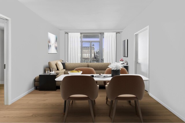 dining area featuring light wood finished floors and baseboards