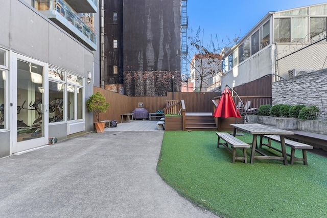 view of home's community featuring fence, a patio area, and a wooden deck