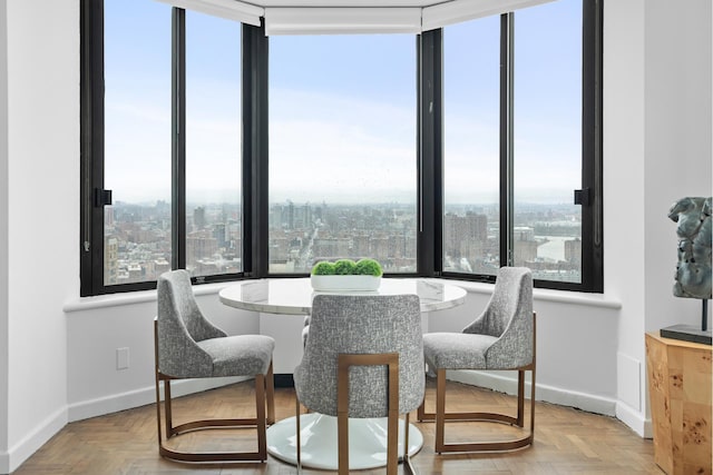 dining room featuring baseboards and a view of city
