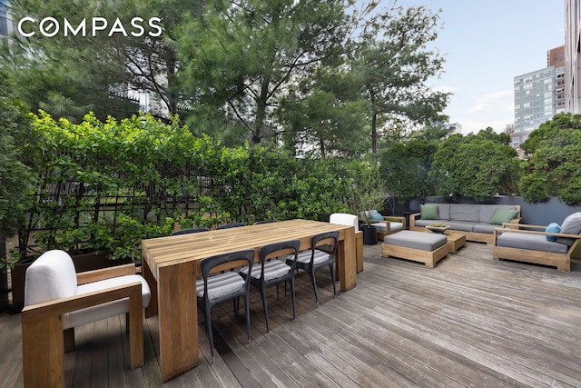 101 Warren St Unit 590, New York City, NY 10007 - wooden terrace featuring outdoor lounge area, outdoor dining space, and view of wooded area