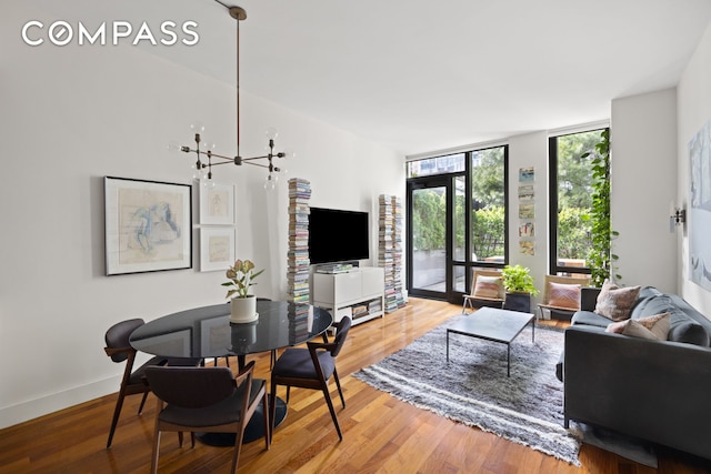living room with a wall of windows, wood finished floors, and baseboards