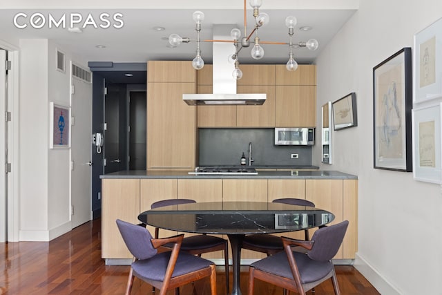 kitchen featuring appliances with stainless steel finishes, light brown cabinets, and modern cabinets