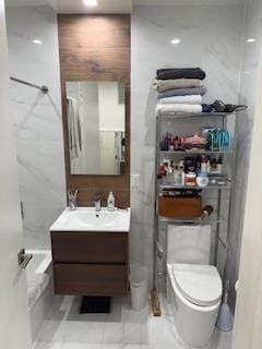 bathroom with toilet, vanity, and tile patterned floors