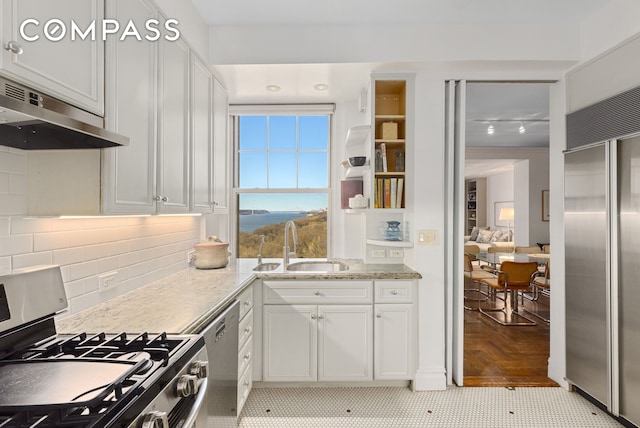 kitchen featuring under cabinet range hood, a sink, white cabinetry, and appliances with stainless steel finishes