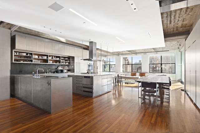 205 W 19th St Unit 11, New York City, NY 10011 - kitchen with island exhaust hood, modern cabinets, dark wood-style floors, gray cabinetry, and a kitchen island