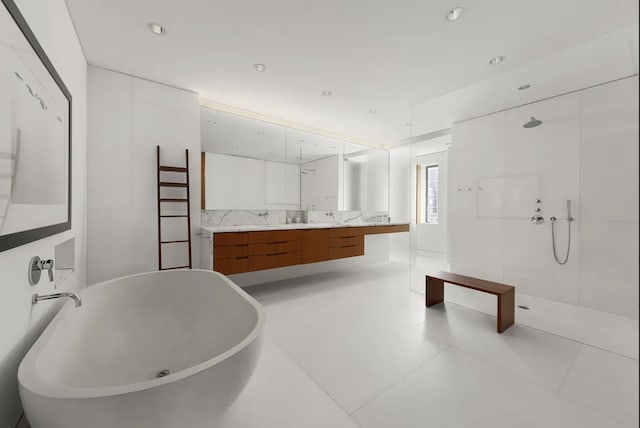 205 W 19th St Unit 11, New York City, NY 10011 - bathroom with a freestanding bath, walk in shower, double vanity, tile patterned floors, and recessed lighting
