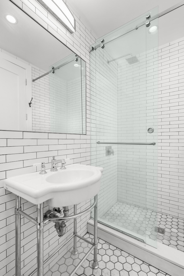 full bath featuring a shower stall, recessed lighting, tile patterned floors, and tile walls