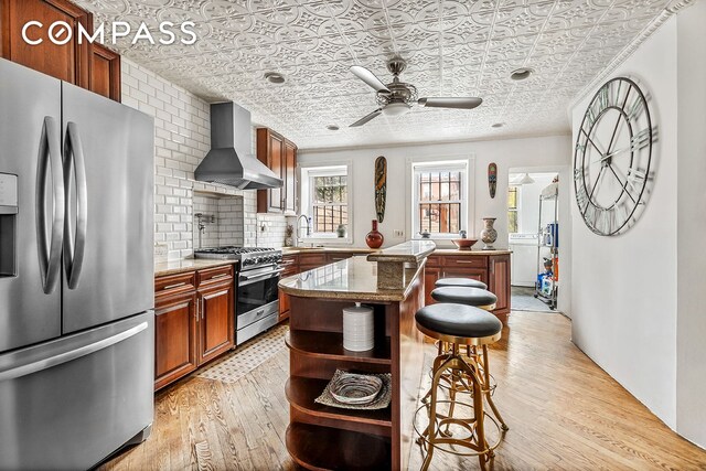 480A Mac Donough St, New York City, NY 11233 - kitchen with stainless steel appliances, wall chimney exhaust hood, an ornate ceiling, a sink, and a kitchen breakfast bar