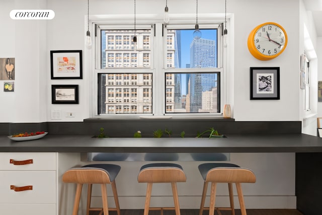 bar featuring hanging light fixtures and a city view