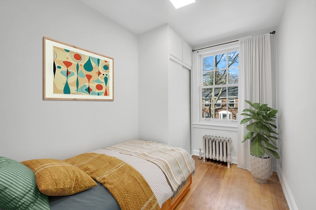 39-39 46th St, New York City, NY 11104 - bedroom featuring baseboards, radiator heating unit, and hardwood / wood-style flooring
