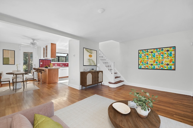 39-39 46th St, New York City, NY 11104 - living room featuring baseboards, stairs, ceiling fan, and wood finished floors