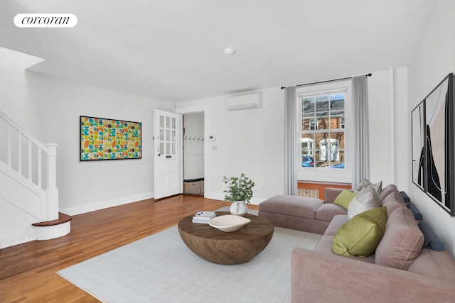 39-39 46th St, New York City, NY 11104 - living room featuring visible vents, wood finished floors, baseboards, stairway, and an AC wall unit
