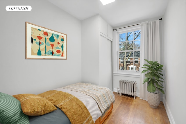 39-39 46th St, New York City, NY 11104 - bedroom with wood-type flooring, baseboards, visible vents, and radiator heating unit