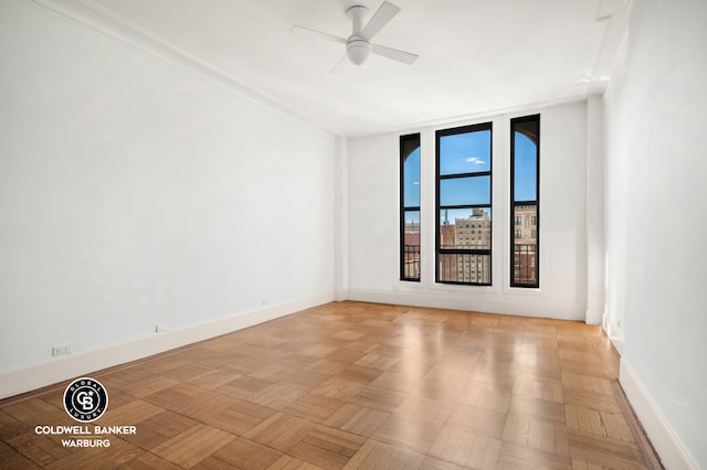 unfurnished room featuring a ceiling fan and baseboards