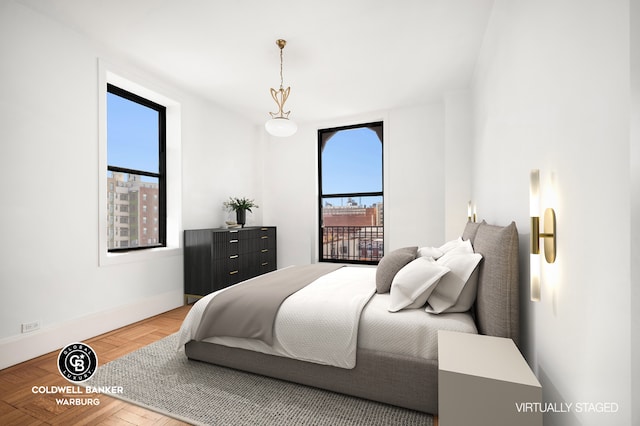 bedroom with baseboards and multiple windows