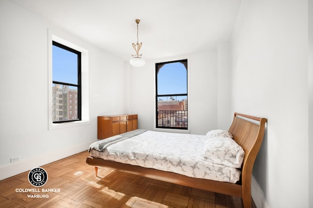 bedroom featuring baseboards and multiple windows