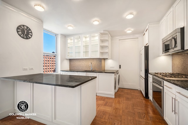kitchen with open shelves, a peninsula, white cabinets, a sink, and stainless steel appliances