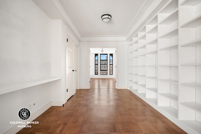 corridor featuring baseboards and built in shelves