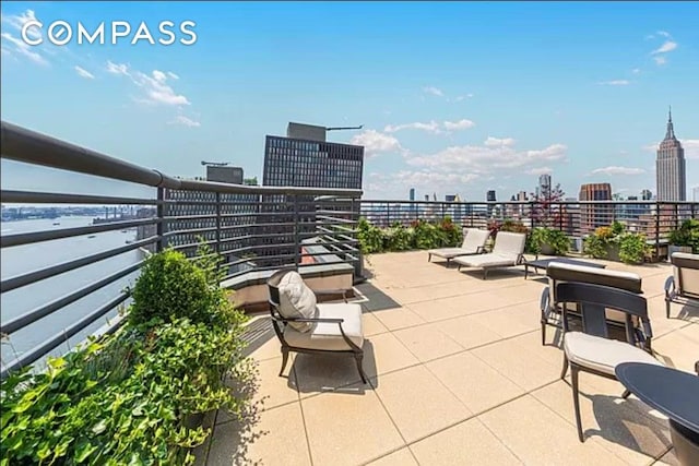 view of patio / terrace with a view of skyline and a balcony